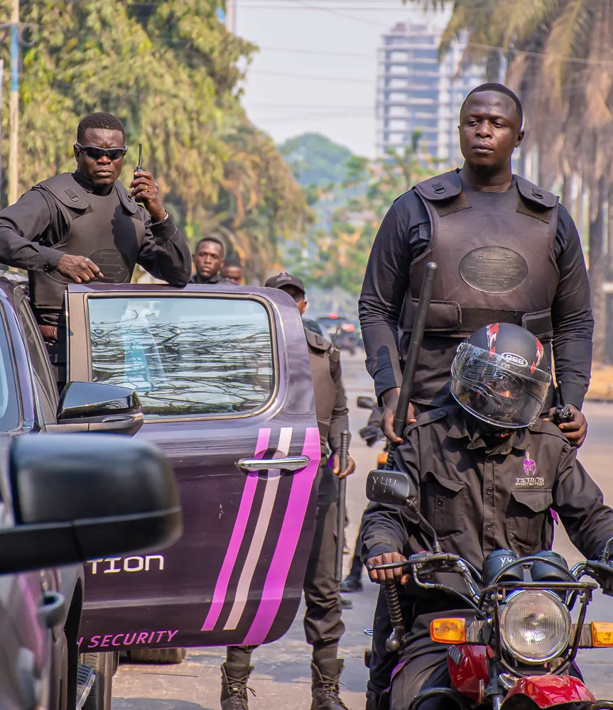 Titans protection officers beside a branded vehicle and motorcycle