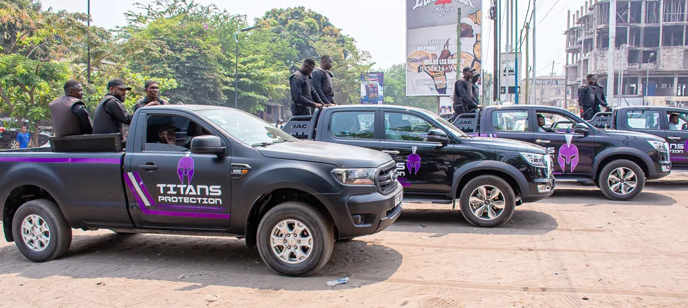 Side view of branded Titans security vehicles lined up outdoors