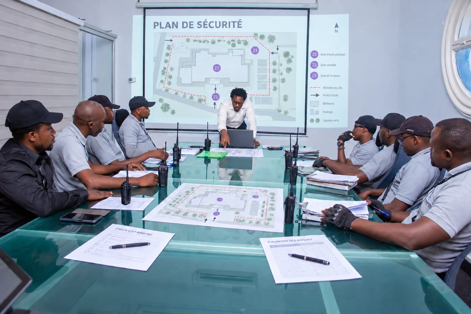 Security-planning visualisation based on a Titans team meeting, with a projected site plan and printed briefing documents