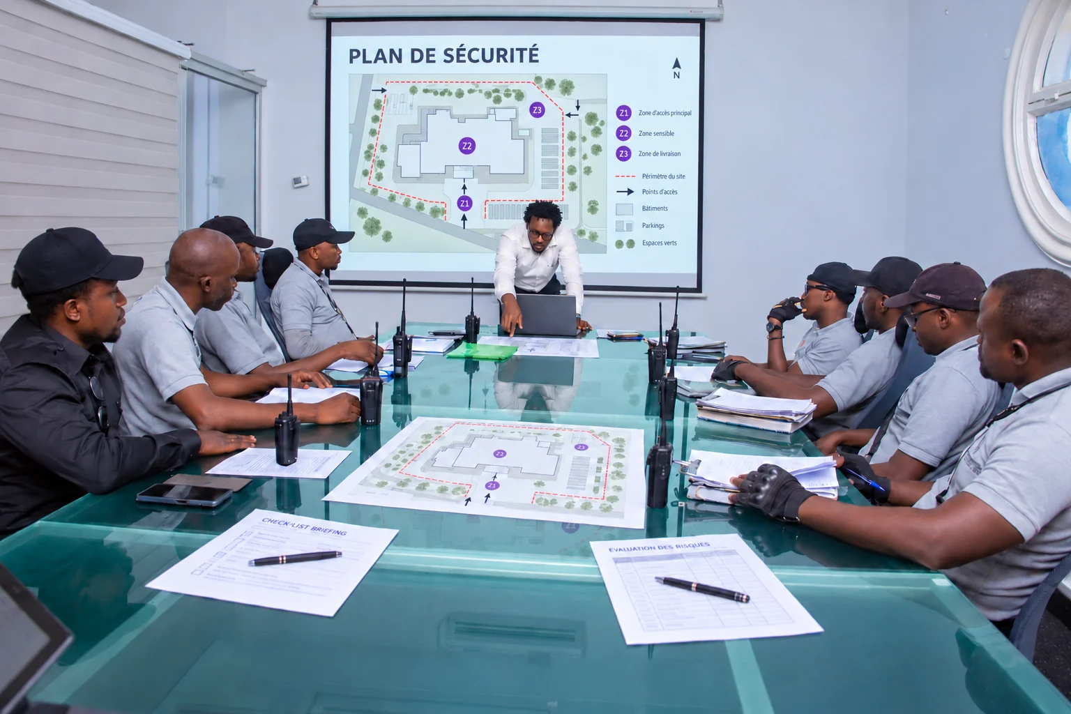 Security-planning visualisation based on a Titans team meeting, with a projected site plan and printed briefing documents